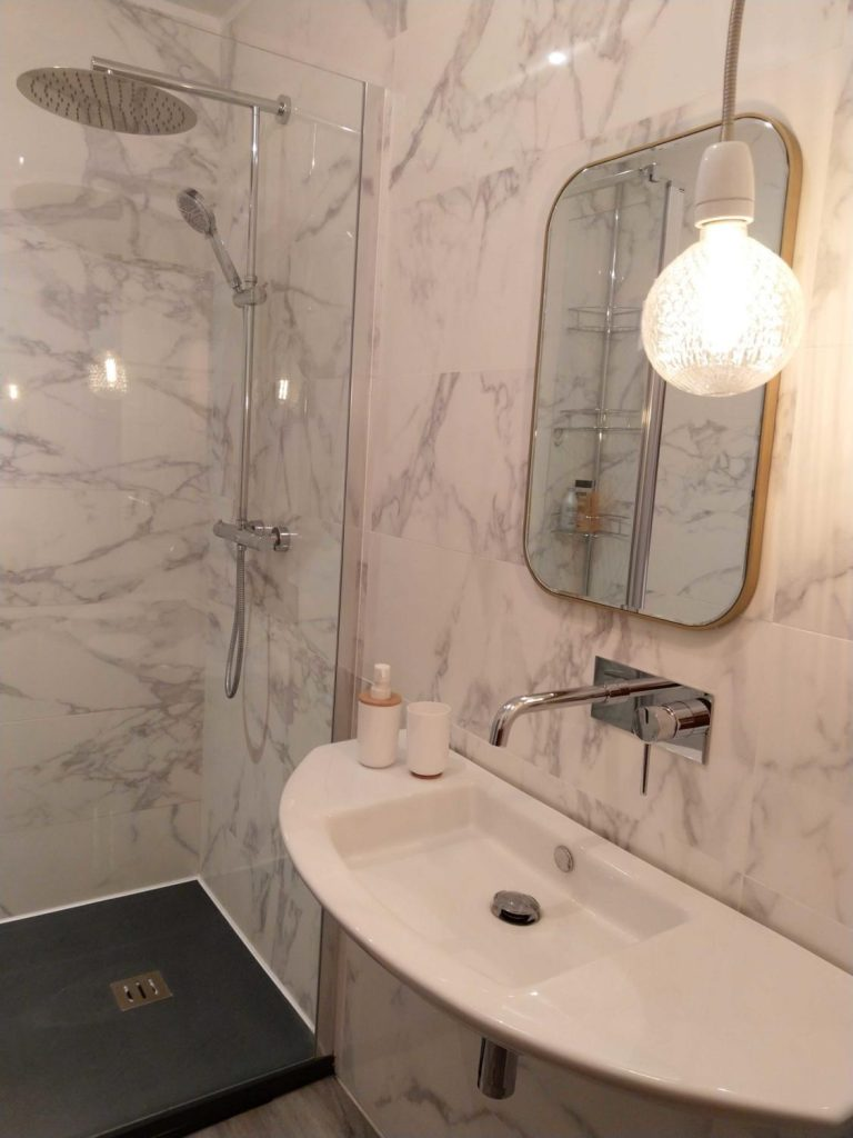 salle de bain avec murs en marbre et douche italienne