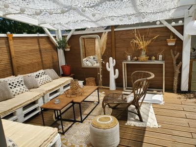 Terrasse au style bohème bois et blanche avec pergola blanche