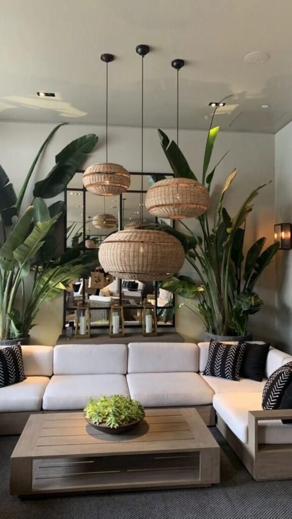 Salon design avec beaucoup de plantes et un ensemble de trois abat-jours style paille
