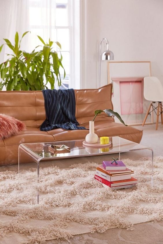 Salon moderne avec un canapé cuir et une table en pvc transparente